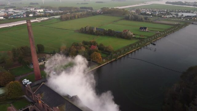 Steam rising up from the ir. D.F. Woudagemaal Steam Pumping Station in Lemmer during sunrise. Drone view