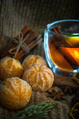 Moscow, Russia, December 2021, still life with tangerines, cinnamon, tea and a spruce branch against a dark wood background
