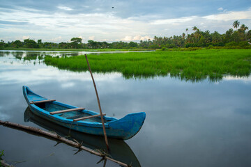 Blue color Wooden boat - Backwaters photography, typical landscape with palm trees and old hut, Kerala Backwaters, Kerala backwaters photography during day time Kadamakkudy Kerala - obrazy, fototapety, plakaty
