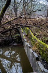 An old moss-covered water channel over a river