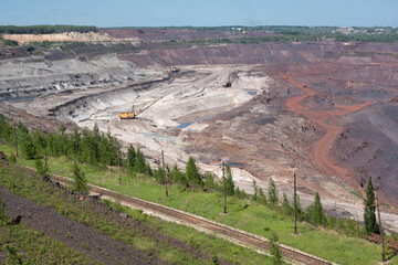 Open iron ore quarry with walking excavator, railway transportation