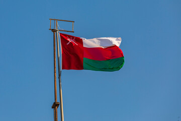 Fototapeta na wymiar Middle East, Arabian Peninsula, Oman, Muscat, Muttrah. Omani flag flying in Muttrah.