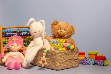 Toy box full of baby kid toys. Container with teddy bear, fluffy and educational wooden toys on...