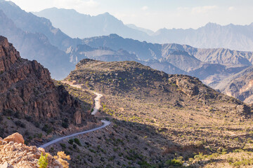 Middle East, Arabian Peninsula, Oman, Al Batinah South, Rustaq. A road passing through the desert mountains of Oman.