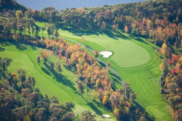 Aerial view of golf course and lake during autumn
