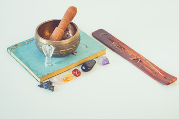 Spiritual altar with handmade journal, burning incense, chakra crystals and tibetan sound bowl 