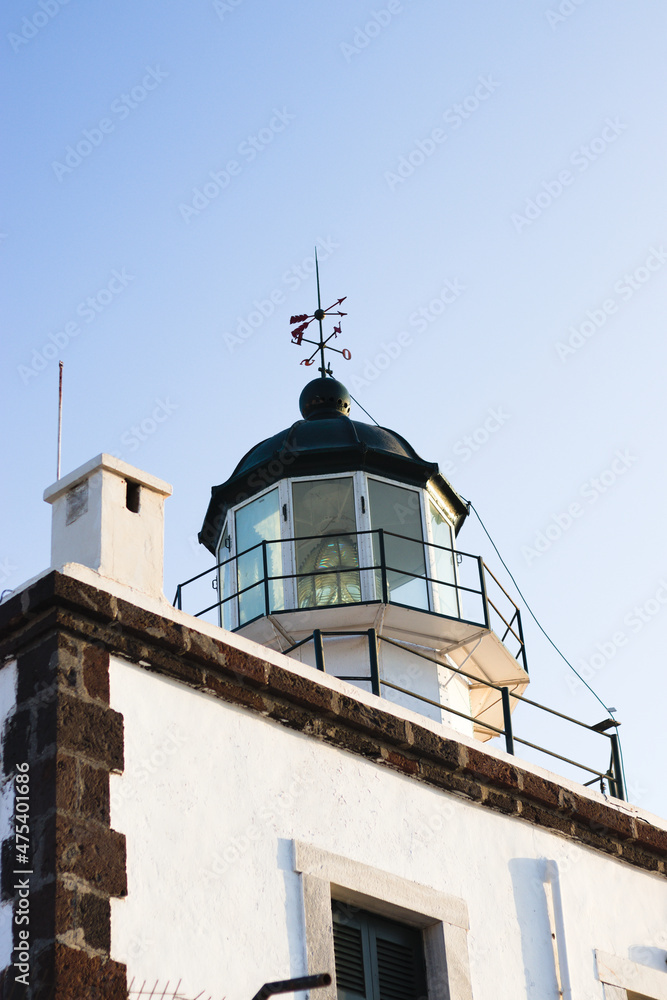 Poster Low angle shot of a white lighthouse in Santorini