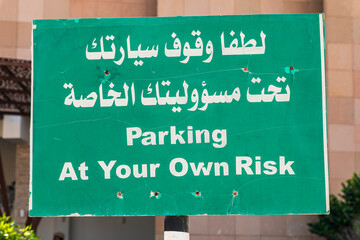 Obraz premium Middle East, Arabian Peninsula, Oman, Al Batinah South. Parking sign in English and Arabic.