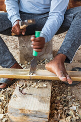 Middle East, Arabian Peninsula, Al Batinah South. Worker chiseling bamboo at a boatyard in Oman.