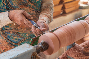 Middle East, Arabian Peninsula, Oman, Al Batinah South. Worker turning wood on a lathe.