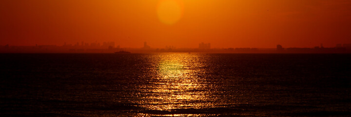 Panorama sunset in Istanbul, Turkey. You can see the sun reflected in the water and some of the skyscrapers on the European side of the city.