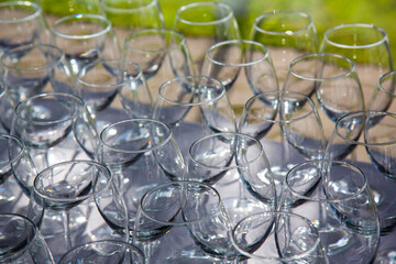 a large number of shiny glass glasses on a tray