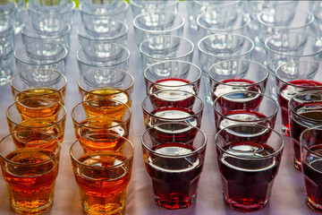 a large number of shiny glass glasses on a tray