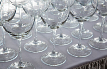 a large number of shiny glass glasses on a tray