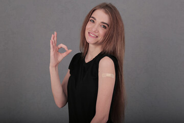 a girl vaccinated against coronavirus with a gesture shows that everything is in order. patch on...
