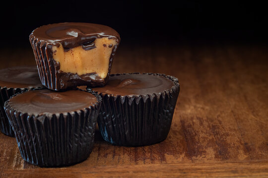 Dark chocolate peanut butter cups on a wood table