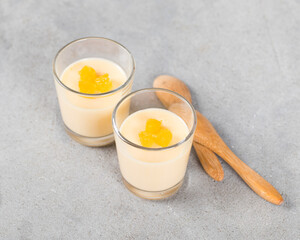 Mandarin cream jelly, Panna Cotta in a glass on a light gray background