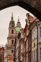 Fototapeta na wymiar Prague, Czech Republic. View of church and other buildings from under an arch.