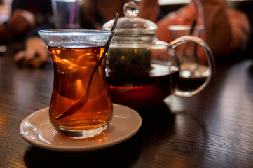 Modern glassy teapot and cup of fresh tea