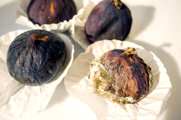 Mold on ripe purple figs close - up . Selective focus. Mold spores during fruit transportation. Fruit damage during storage by poisonous mold fungi