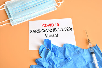 Covid-19 new Omicron variant. Medical face masks, blue medical gloves, vaccine syringe with white paper and 