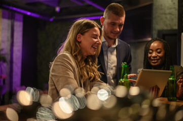Cheerful colleagues drinking beer in the bar together after work