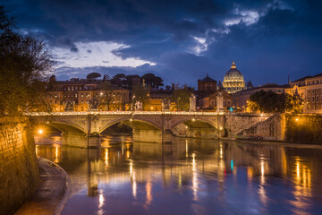 Europe, Italy, Rome. Dome of Sistine Chapel with Tiber River and bridge lit at sunset.
