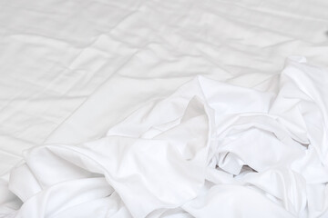 White crumpled cotton linen background, wavy bed cloth after night sleep in the morning