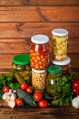 Preserved autumn vegetables on shelf near a brown wooden wall