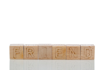 Wooden cubes with letters friend on a white background