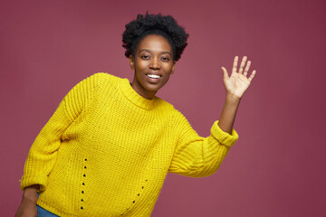 Greeting gesture. Friendly modern african american young girl waving hand, smiling. Hospitable...