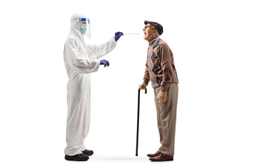 Full length profile shot of an epidemiologist in a hazmat suit  testing an elderly man for covid-19