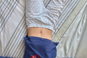 girl lying on a bed with her belly button exposed