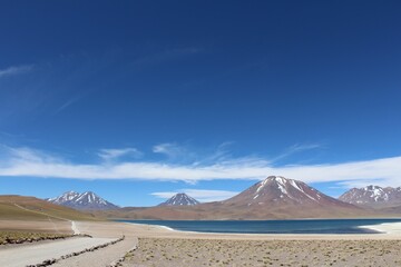 Sceninc view of path leading to Miscanti and Miniques lagoons, volcanos on the background, Chile.