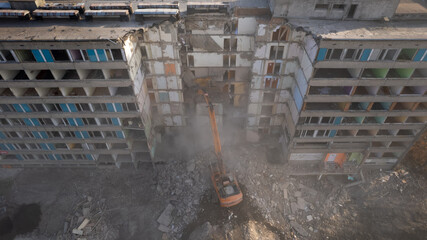 Excavator for dismantling buildings, using a special claw, dismantles a multi-storey building. View...