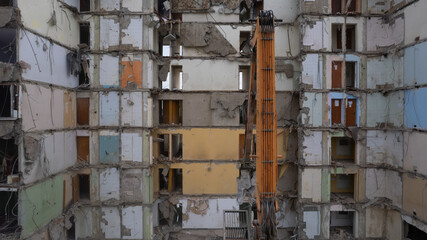 Excavator for dismantling buildings, using a special claw, dismantles a multi-storey building. View from above