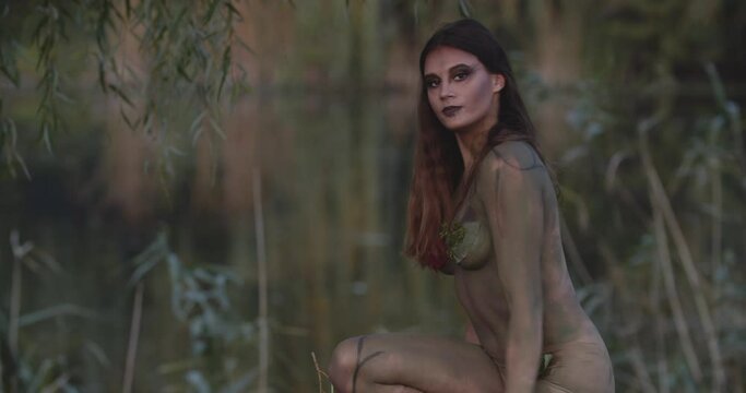 Beautiful young woman posing in the forest as dryad, makeup and body art, 4k