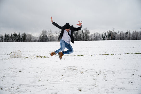 Joyful young man jumping in the snow