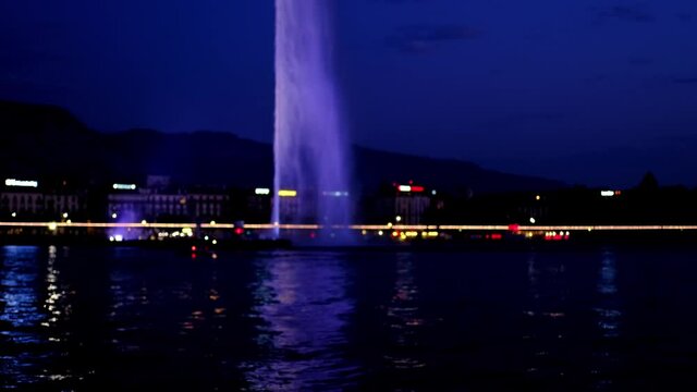 jets of a natural fountain in the dark of the night in the center of Lake Geneva, Geneva Water Fountain, connected to the city by a pedestrian bridge, concept tourism, sights of Europe
