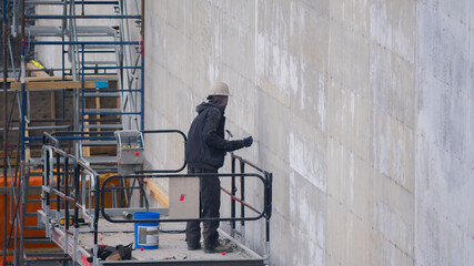 construction site scaffolding man at work lift hammer nail concrete wall building
