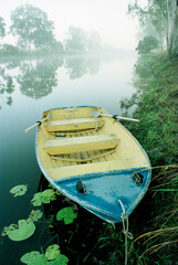 Row boat on the bank of a creek in the fog