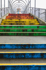 New Westminster BC rainbow coloured staircase leading to River Market. Bridge over railways with...