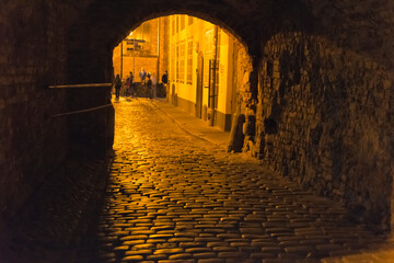 Night view of city gate and cobblestone street in the old town, Riga, Latvia
