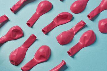 Pink party plastic balloons on a blue background.