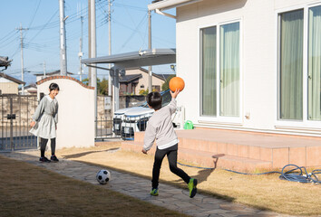 庭でボール遊びをする子供