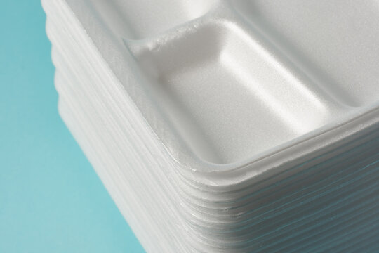 white Styrofoam plastic plates on blue background. Trash plastic, reusable plastic, disposable, for food.