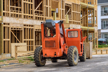 Fototapeta na wymiar Wood building frame on new residential construction home framing home boom truck forklift in the new home