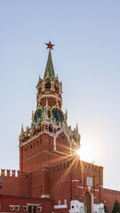 Fototapeta na wymiar Spasskaya Tower of Moscow Kremlin on Red Square, Russia. Blue sky background with sunbeams