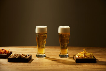A glass and bottle of beer and fried potatoes spicy chicken floss in grey background ,  mug of beer for food and drinking advertising front view
