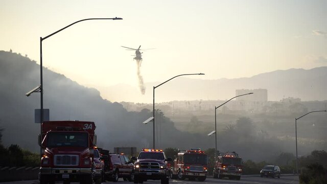 fire trucks fight brush fire with helicopter
